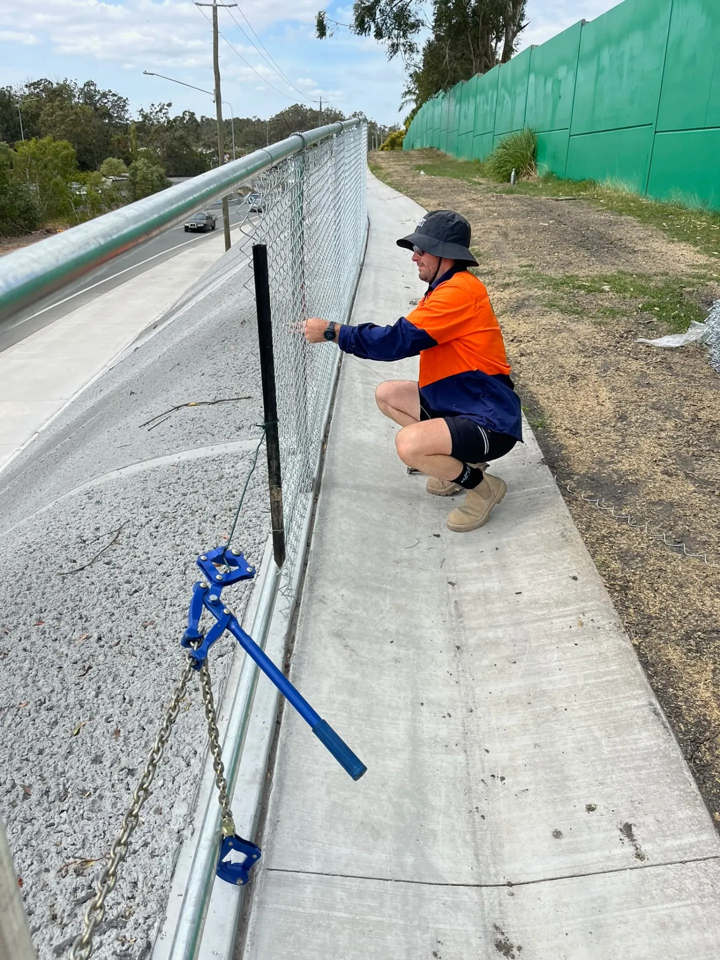 Wood Trades crew tensioning chainwire fencing at a storage facility